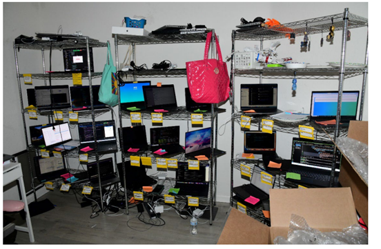 DOJ evidence photograph of company laptops arranged on metal shelves in the Chapman residence
